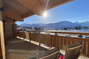 A balcony with a view of a snowy mountain range