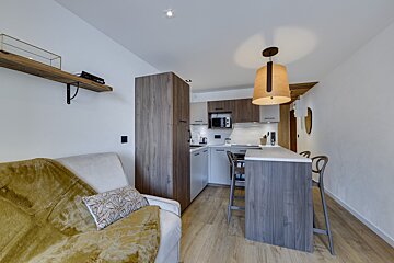 A living room with a couch and a kitchen