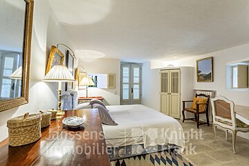 A bedroom with a large bed and a desk that says janssens knight