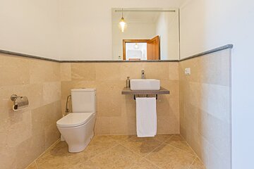 A bathroom with a toilet a sink and a mirror