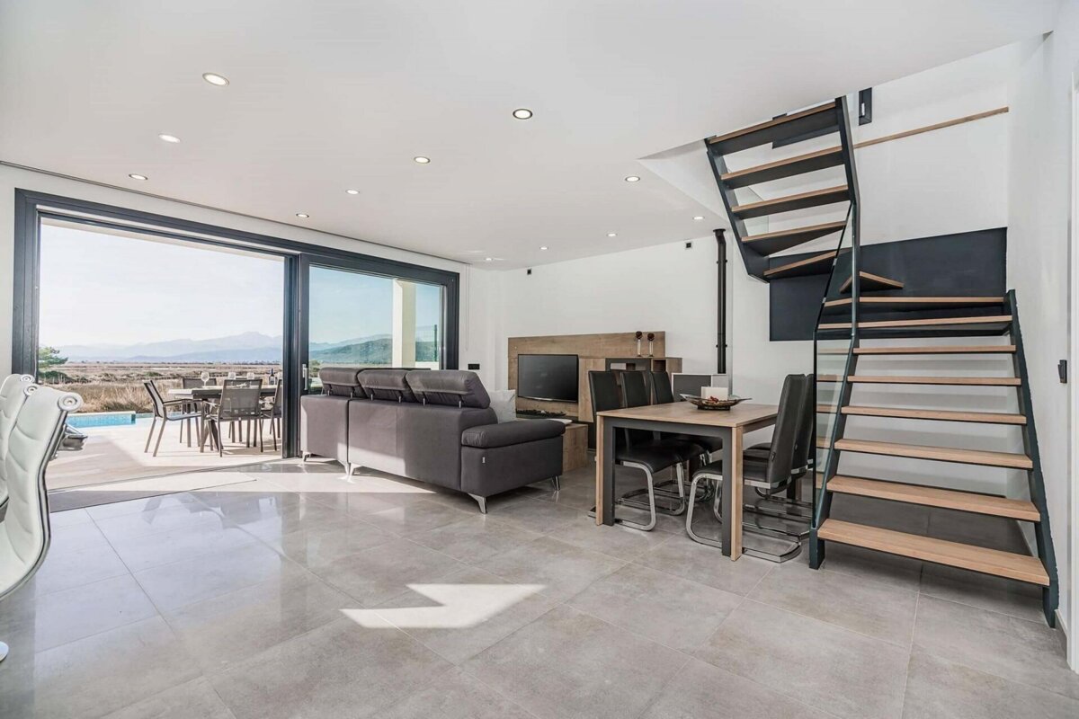 A living room with a spiral staircase leading up to the second floor