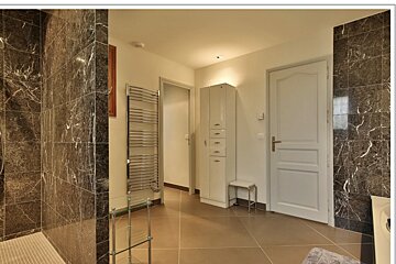 A bathroom with marble tiles and a towel rack