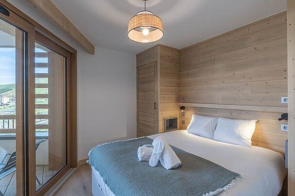 A bedroom with a large bed and a large window