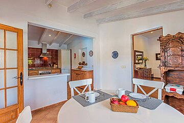 A dining room table with a basket of fruit on it