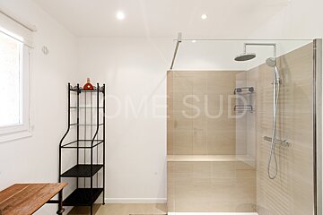 A bathroom with a shower and a shelf that says home sud