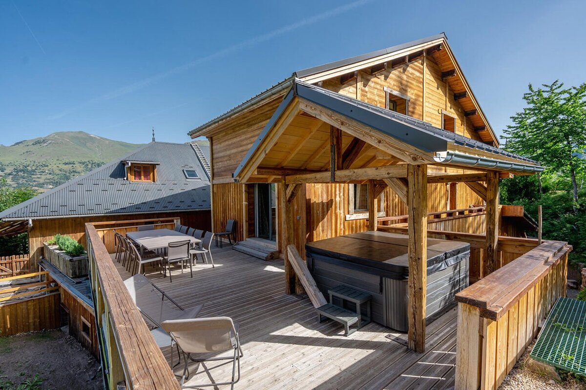 A wooden house with a hot tub on the deck