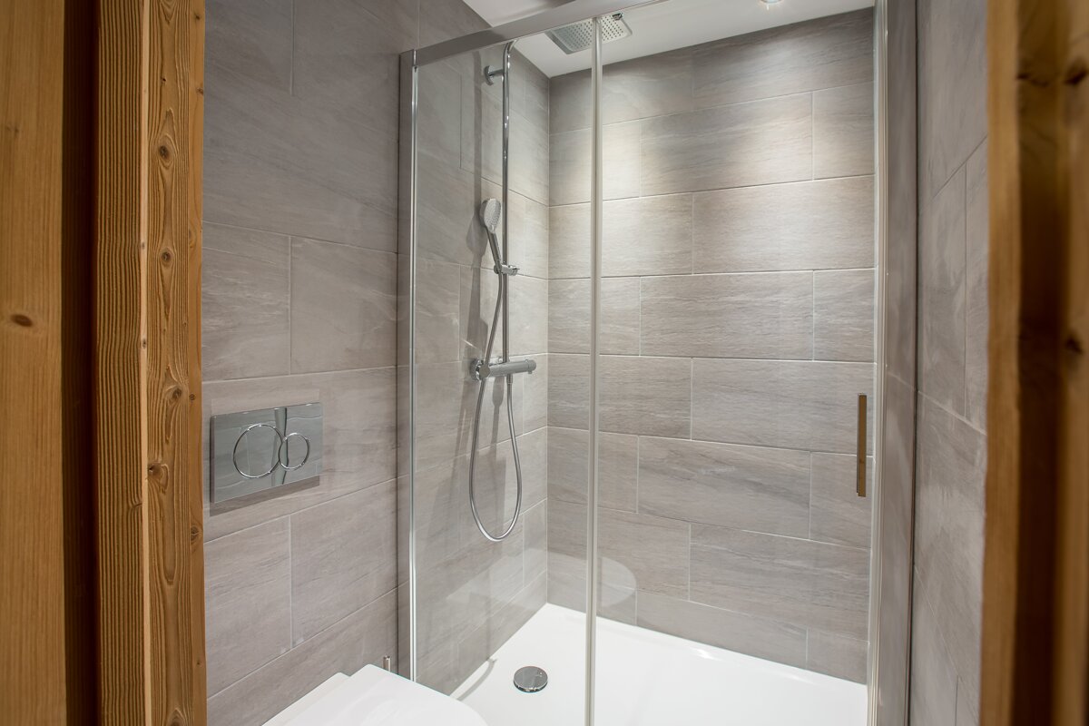 A bathroom with a toilet and a shower with a glass door