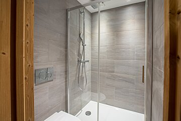A bathroom with a toilet and a shower with a glass door