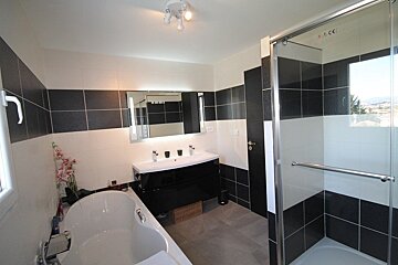 A bathroom with black and white tiles and a ce sign on the wall