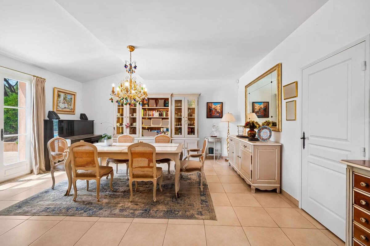 A dining room with a table and chairs and a chandelier