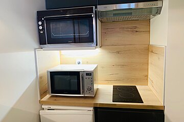 A small kitchen with a microwave oven and a stove