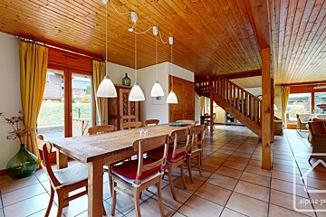 A dining room with a wooden table and chairs and a sign that says alpine-pro