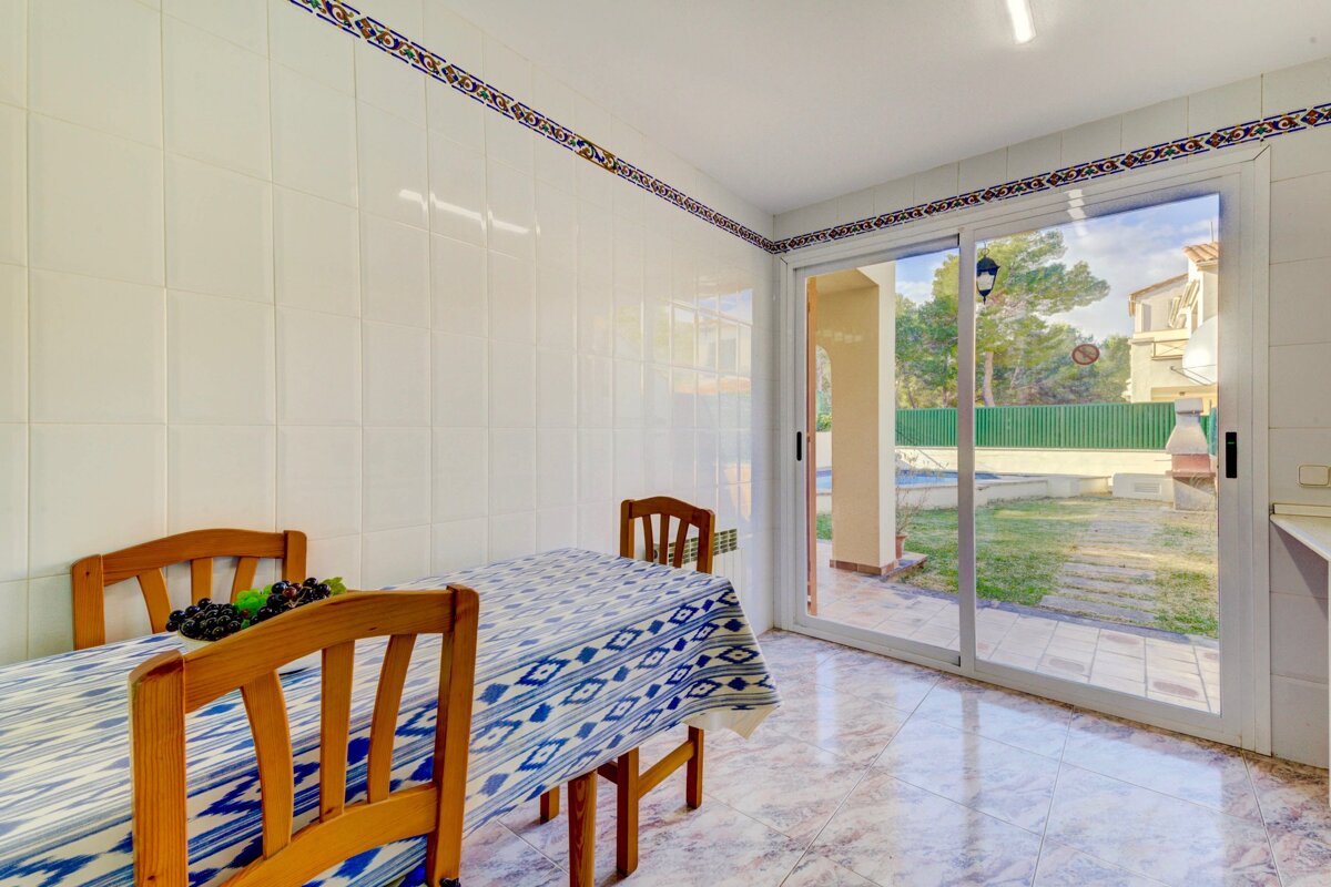 A kitchen with a table and chairs and a sliding glass door