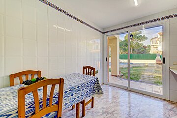 A kitchen with a table and chairs and a sliding glass door