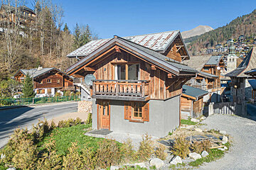 A snowy house with a mountain in the background