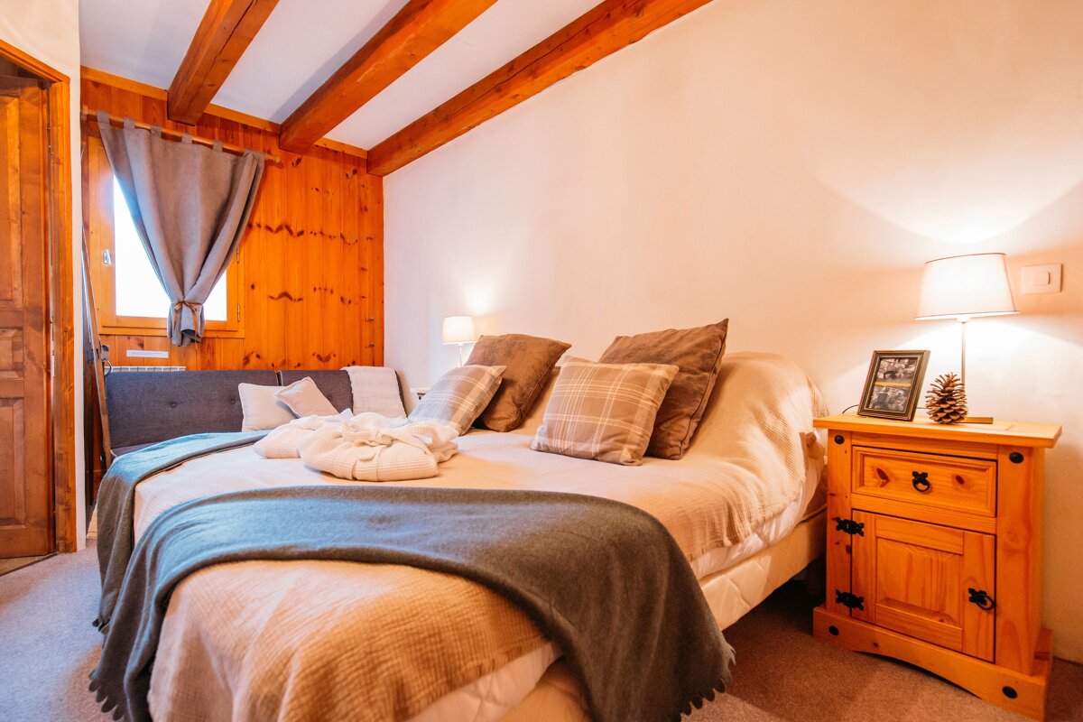 A bedroom with a bed and a nightstand with a picture on it