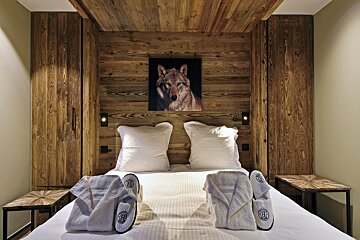 A bedroom with a picture of a wolf on the wall