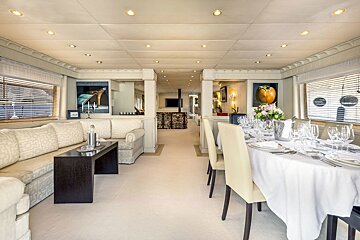 A dining room with a table and chairs and a couch
