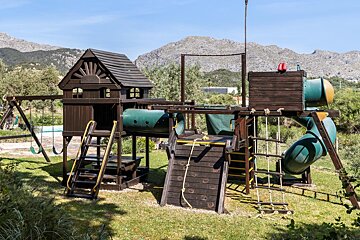 A wooden playground with mountains in the background