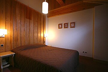 A bedroom with a bed and three pictures on the wall