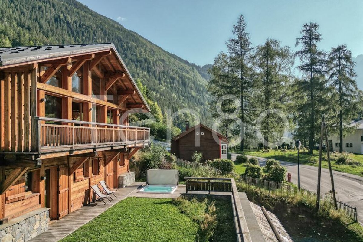 A large wooden house with a hot tub in front of it
