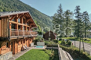 A large wooden house with a hot tub in front of it