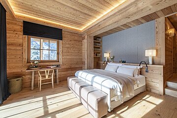 A bedroom with a large bed and a desk