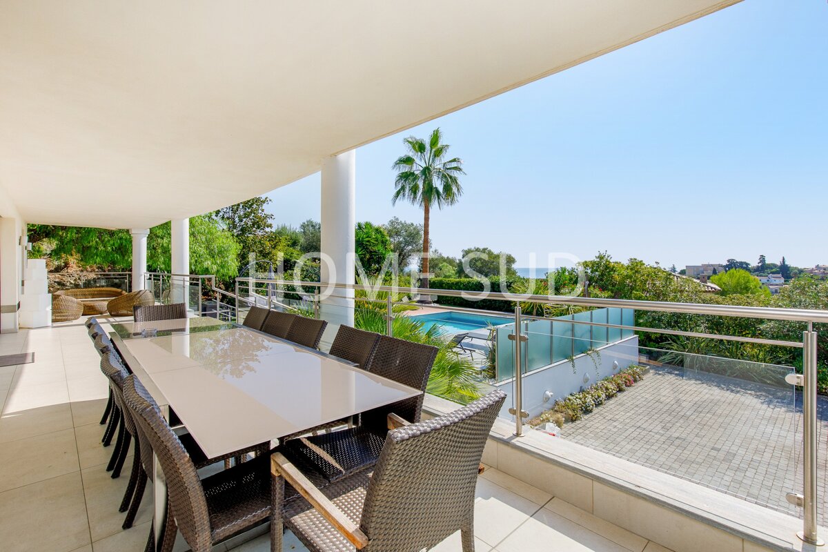A table and chairs on a balcony with a sign that says homesud