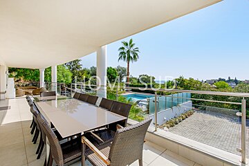 A table and chairs on a balcony with a sign that says homesud
