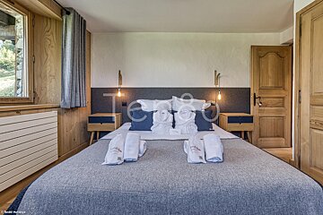 A bedroom with a bed and two nightstands and the word tenda on the wall