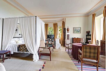 A bedroom with a canopy bed and a table