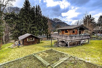 A mountain base real estate advertisement with a cabin in the background