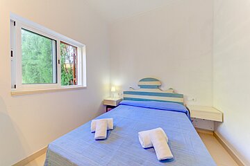 A bedroom with a blue and white striped headboard