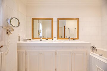 A bathroom with two sinks and two mirrors