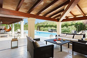 A patio with a couch and a table with watermelon on it