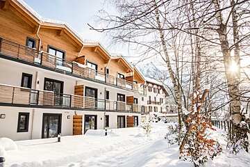A snowy landscape with a building that says ' hotel ' on it