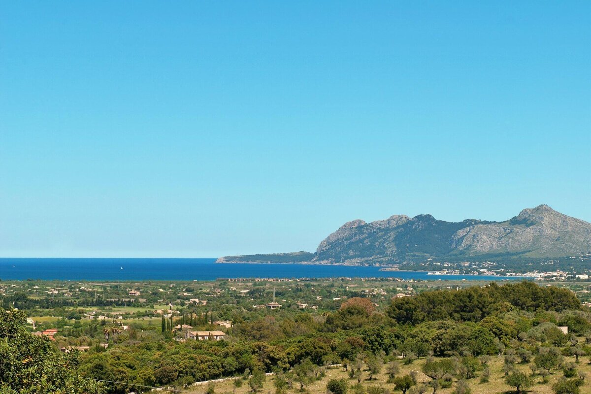 A landscape with mountains and a body of water in the background