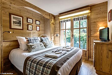 A bedroom with a king size bed and a television