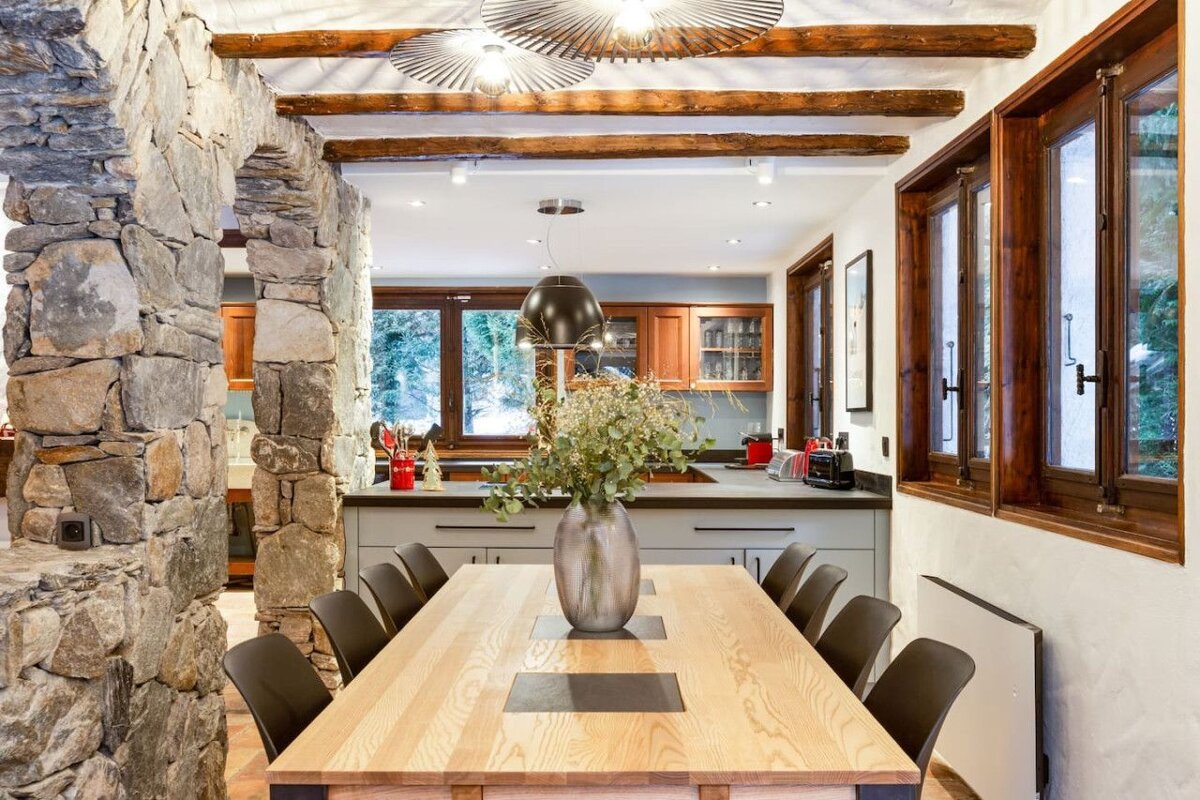 A dining room table with a vase of flowers on it