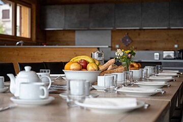 A long table with a bowl of fruit on it