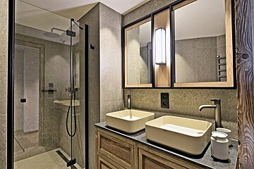 A bathroom with two sinks and a shower