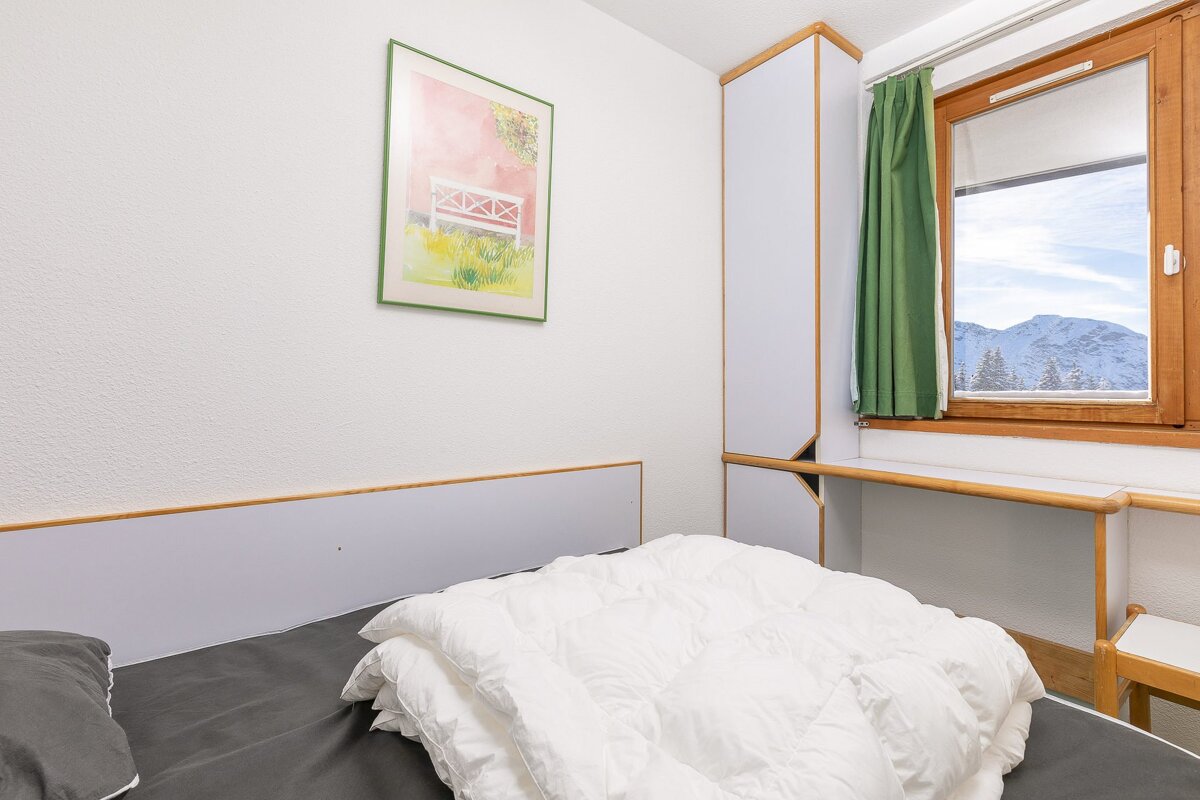A bedroom with a bed and a picture on the wall