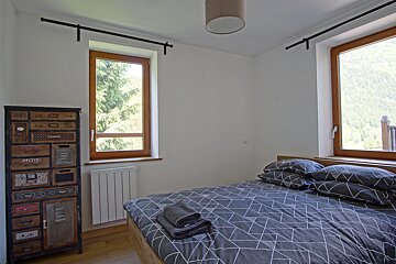 A bedroom with a bed and a chest of drawers that says ' music ' on it