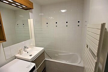 A bathroom with a washer and dryer and a bathtub