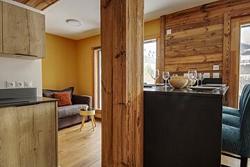 A kitchen with a couch and a table with glasses on it