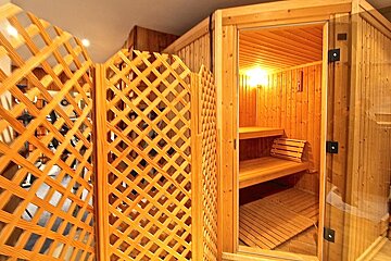 The inside of a wooden sauna with a glass door