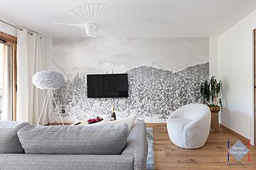 A living room with a rental designer logo in the corner