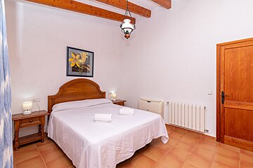 A bedroom with a bed and a picture on the wall