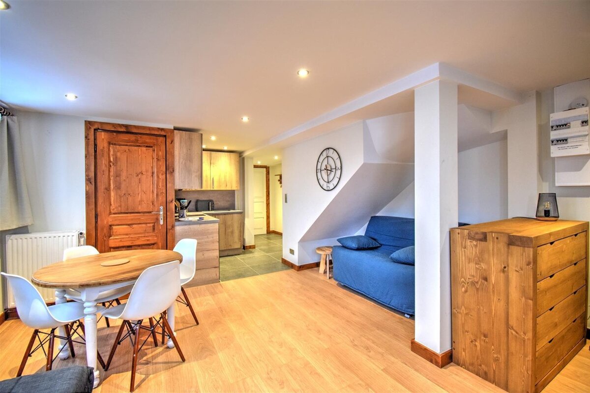 A living room with a table and chairs and a blue couch