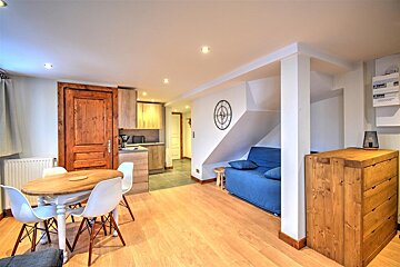 A living room with a table and chairs and a blue couch